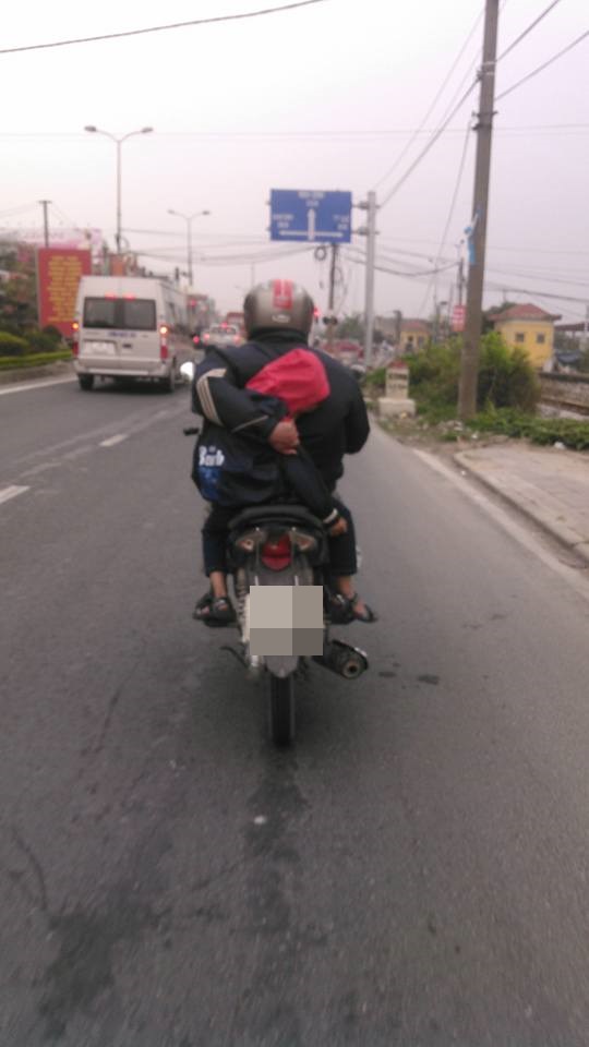 Hà Nam: Người cha một tay lái xe máy, một tay ôm con ngủ trên đường quốc lộ - Ảnh 1.