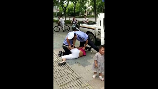 Tranh cãi với cảnh sát, mẹ đang bế con bị quật ngã sấp mặt vì lý do không thể chấp nhận - Ảnh 1.