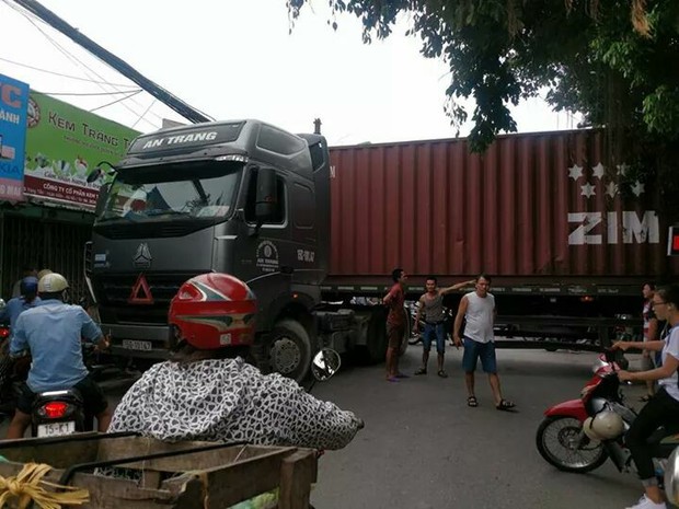 Bất chấp nguy hiểm, người dân thi nhau chui gầm container chắn ngang giữa đường để lưu thông - Ảnh 1. Bất chấp nguy hiểm, người dân thi nhau chui gầm container chắn ngang giữa đường để lưu thông - Ảnh 1.