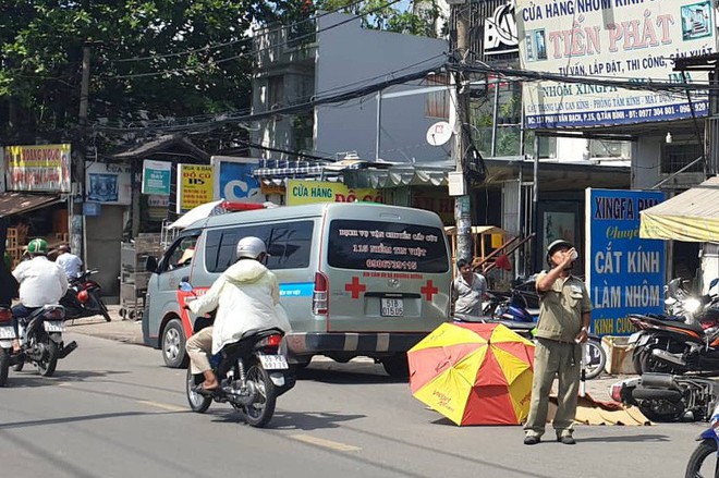 TP.HCM: Cô gái 20 tuổi bị xe tải cán tử vong thương tâm, người dân dùng ô che nắng cho thi thể - Ảnh 1.