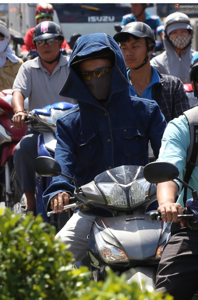 Nắng nóng liên tục nhiều ngày ở Sài Gòn, người dân tìm cách bảo vệ da khỏi tia UV gần chạm ngưỡng khi ra đường - Ảnh 6.