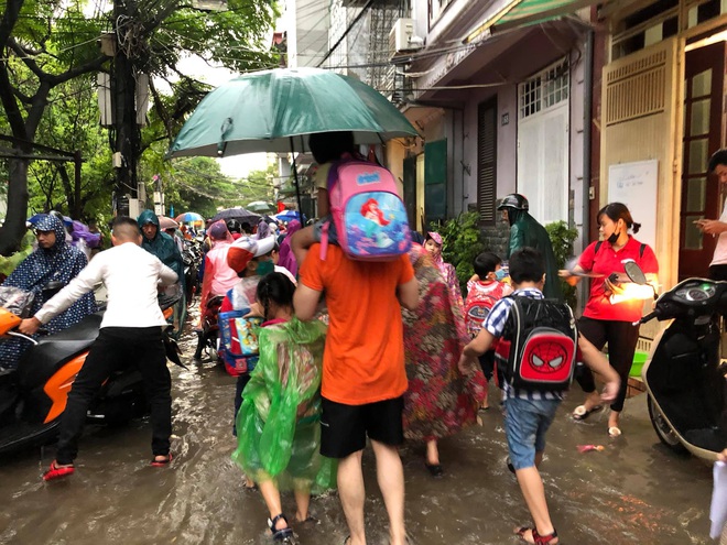 Ảnh: Cơn mưa xối xả đổ xuống Hà Nội giờ tan học khiến nhiều phụ huynh, học sinh mệt nhoài trên đường về nhà - Ảnh 2. Ảnh: Cơn mưa xối xả đổ xuống Hà Nội giờ tan học khiến nhiều phụ huynh, học sinh mệt nhoài trên đường về nhà - Ảnh 2.