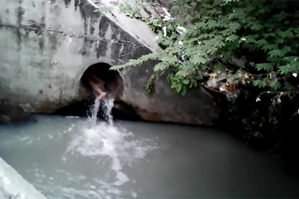 C&ocirc; g&aacute;i trẻ kh&ocirc;ng hiểu sao lại chui hẳn v&agrave;o cống nước v&agrave; nằm đ&oacute;.