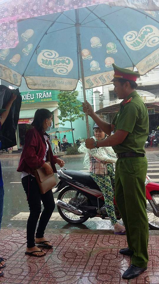 Hình ảnh đẹp mùa thi: Chú công an cầm chiếc ô lớn để che mưa cho thí sinh ở Tây Ninh - Ảnh 2.