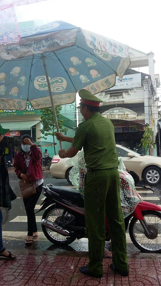 Hình ảnh đẹp mùa thi: Chú công an cầm chiếc ô lớn để che mưa cho thí sinh ở Tây Ninh - Ảnh 1.