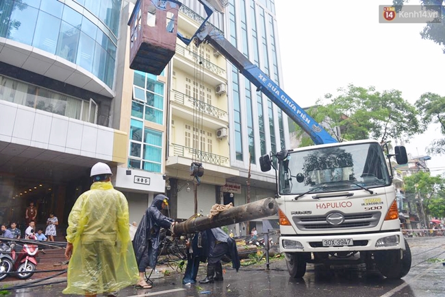 Chùm ảnh: Lực lượng cứu hộ và người dân Hà Nội tất bật dọn dẹp hậu quả bão số 1 - Ảnh 9.