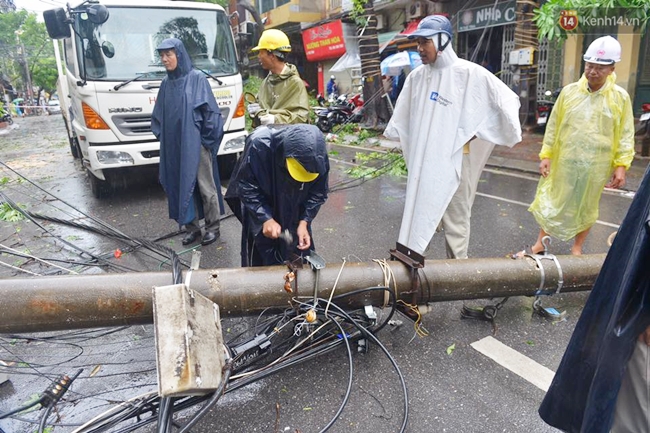 Chùm ảnh: Lực lượng cứu hộ và người dân Hà Nội tất bật dọn dẹp hậu quả bão số 1 - Ảnh 11.