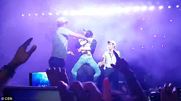 Fan nữ nhảy lên quặp chân ôm cứng Enrique Iglesias, nhất quyết không rời sân khấu - Ảnh 5.