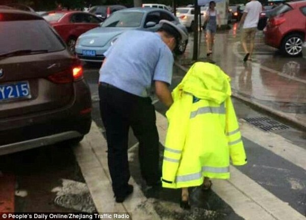 Hình ảnh cảnh sát trẻ dầm mưa nhường áo bảo hộ cho em bé đi lạc khiến hàng triệu trái tim tan chảy - Ảnh 2.