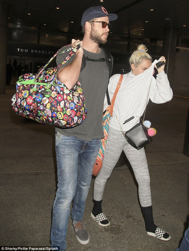 Miley Cyrus tay trong tay Liam Hemsworth, che mặt khỏi ống kính máy ảnh - Ảnh 4.
