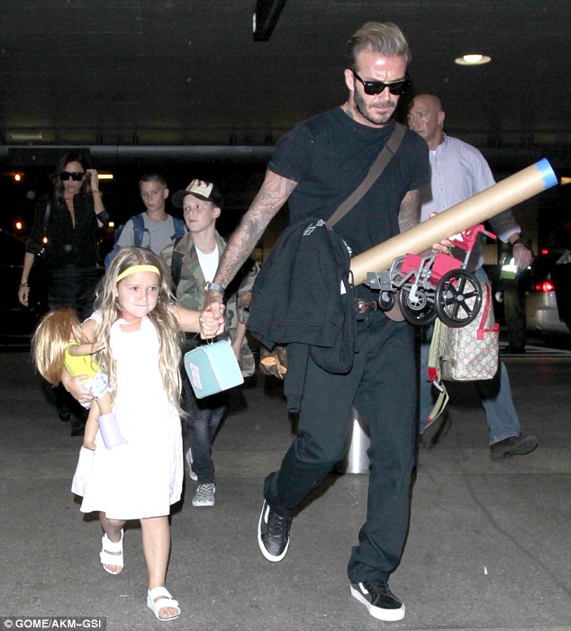 Beckham cực đáng yêu khi giúp bé Harper chăm sóc búp bê bị thương ở sân bay - Ảnh 1.