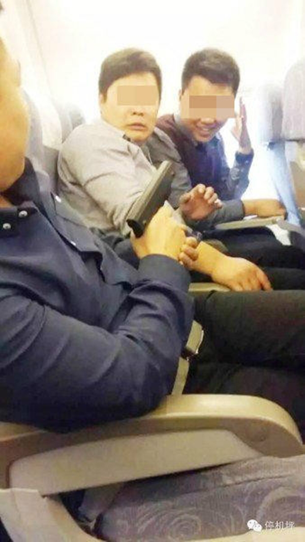 Trung Quốc náo loạn vì bức ảnh người đàn ông cầm súng trên máy bay - Ảnh 1.
