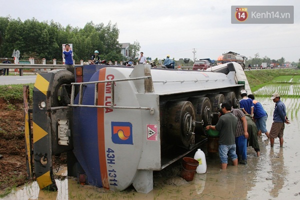 Xe bồn chở hàng trăm lít dầu lao xuống ruộng, người dân ùa ra hứng dầu tràn - Ảnh 1.