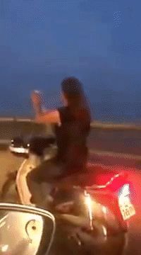 Clip: Cô gái trẻ vừa điều khiển xe máy, vừa chụp ảnh tự sướng trên cầu Vĩnh Tuy - Ảnh 2.