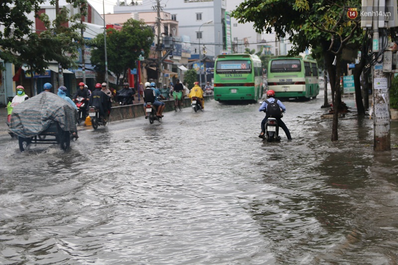 Image result for Rạng sáng 13.10, sau cơn mưa lớn, nước từ các kênh rạch đổ vào khu dân cư ở phường Tân Thới Nhất, quận 12.