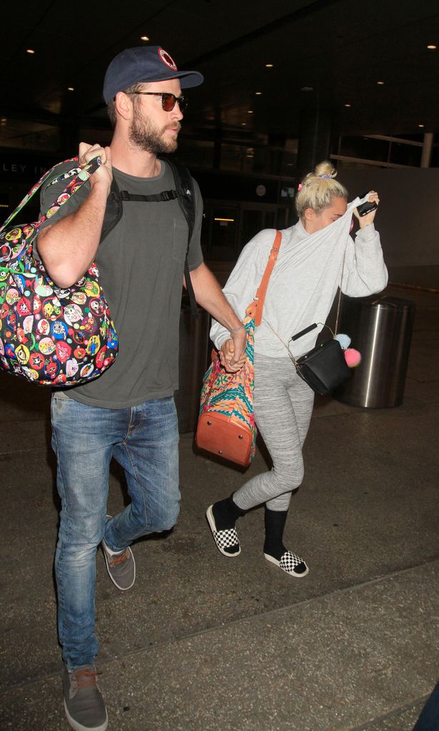 Miley Cyrus tay trong tay Liam Hemsworth, che mặt khỏi ống kính máy ảnh - Ảnh 3.