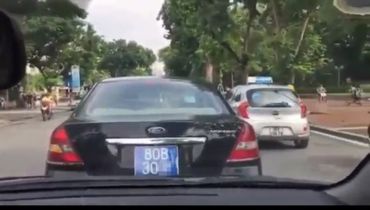 B&eacute; g&aacute;i cầm v&ocirc;-lăng xe biển xanh 80B chạy tr&ecirc;n phố H&agrave; Nội - Ảnh 2.