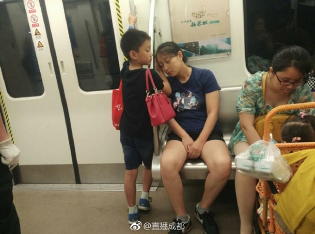 Cậu bé soái ca nhường ghế cho phụ nữ, lấy tay làm gối đỡ cho mẹ ngủ trên tàu điện ngầm - Ảnh 1.