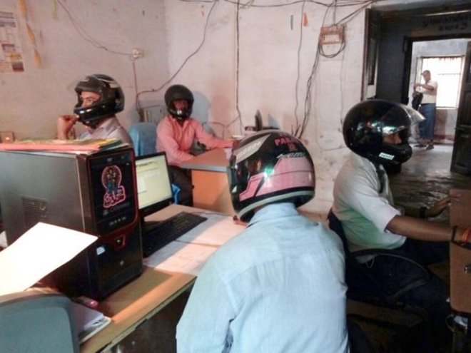 Sợ trần nhà sập vào đầu, nhân viên văn phòng Ấn Độ đồng loạt đội mũ bảo hiểm để bảo toàn tính mạng - Ảnh 1.