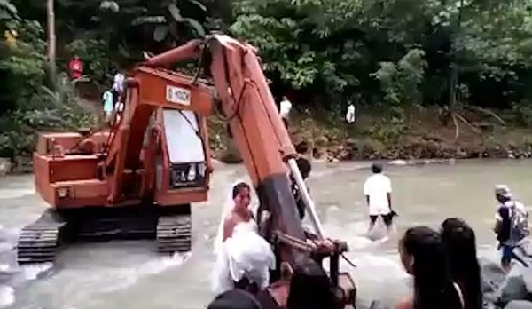 Video: Nước dâng cao chắn lối, cặp uyên ương dùng máy xúc vượt suối về nhà trong đám cưới - Ảnh 2.
