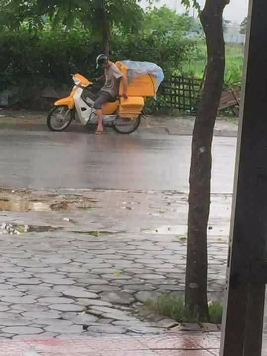 Người đàn ông shipper chịu ướt người để lấy áo mưa che lại đống hàng cho khách - Ảnh 2.