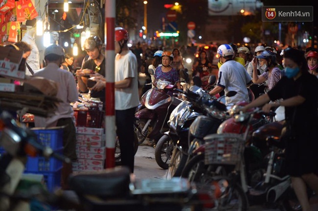 Người dân Hà Nội đổ xô ra vỉa hè mua bánh Trung thu đại hạ giá 15.000 đồng/cái, giao thông hỗn loạn - Ảnh 1.