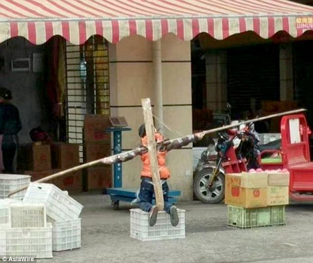Kh&ocirc;ng l&agrave;m b&agrave;i tập, cậu b&eacute; bị cha bắt quỳ v&agrave; tr&oacute;i tay suốt nhiều giờ tr&ecirc;n phố - Ảnh 1.