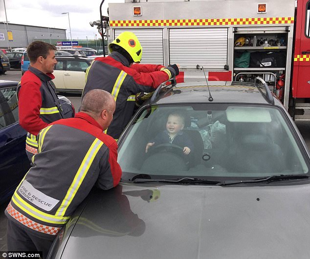 Bé trai 14 tháng tuổi cười nắc nẻ khi 5 nhân viên cứu hỏa ra sức tìm cách cứu cậu bé ra khỏi ô tô - Ảnh 1.