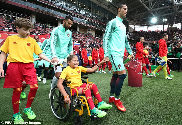 Ronaldo như một người cha, ân cần đẩy xe lăn cho cô bé mascot khuyết tật - Ảnh 1.