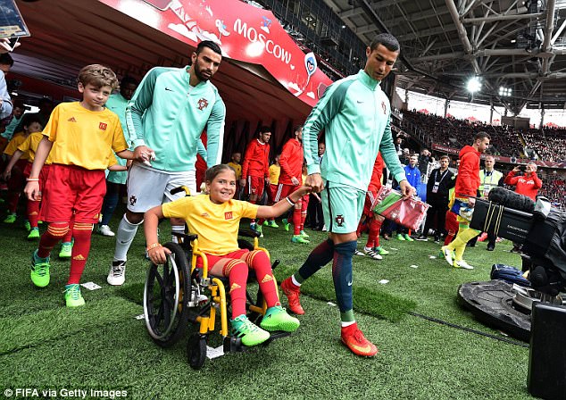 Ronaldo như một người cha, ân cần đẩy xe lăn cho cô bé mascot khuyết tật - Ảnh 2.