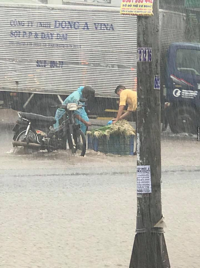 Hình ảnh đẹp: Chàng trai lao ra ngoài mưa để phụ người đàn ông nhặt lại rau bị rớt trên đường ngập - Ảnh 1.