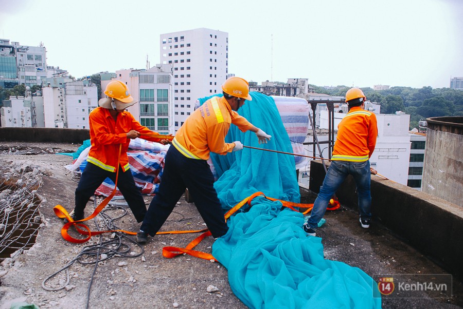 Cận cảnh phá dỡ thuỷ đài khổng lồ bỏ hoang ngay trung tâm Sài Gòn, búa tạ đập 4 lần liên tiếp mới vỡ - Ảnh 14. Các công nhân vận chuyển giàn giáo bằng dây kéo từ dưới đất lên.