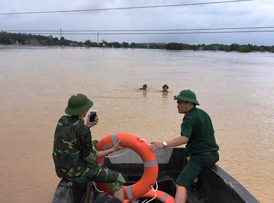 Cứu 2 bố con đang đu dây điện giữa dòng nước lũ - Ảnh 1.