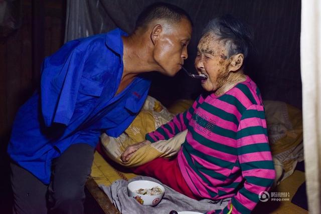 Xót cảnh người con không tay, dùng miệng bón thức ăn cho mẹ già liệt giường 91 tuổi - Ảnh 2.