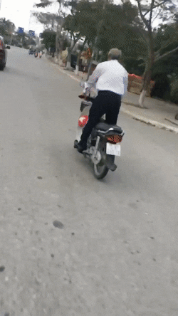 Cụ &ocirc;ng 80 tuổi đứng tr&ecirc;n xe m&aacute;y, lao vun v&uacute;t tr&ecirc;n đường phố - Ảnh 2.