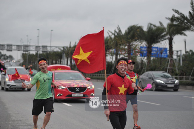 Chùm ảnh: Người hâm mộ cầm cờ Tổ quốc, chạy bộ ra sân bay Nội Bài để đón U23 Việt Nam - Ảnh 7.