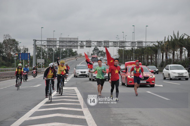 Chùm ảnh: Người hâm mộ cầm cờ Tổ quốc, chạy bộ ra sân bay Nội Bài để đón U23 Việt Nam - Ảnh 6.