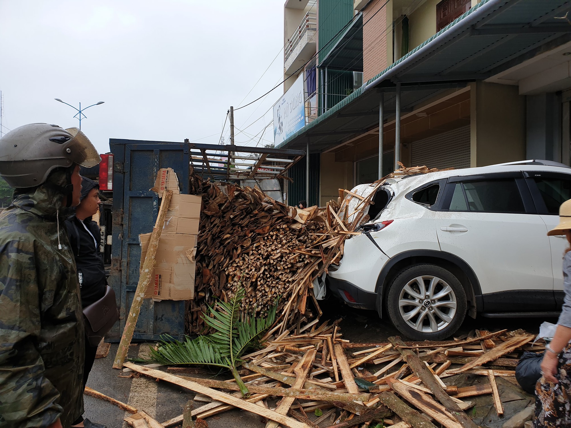 Clip: Tránh cụ ông đạp xe băng qua đường, xe tải chở gỗ lật ngang rồi đè móp đuôi xế hộp CX5 - Ảnh 3.
