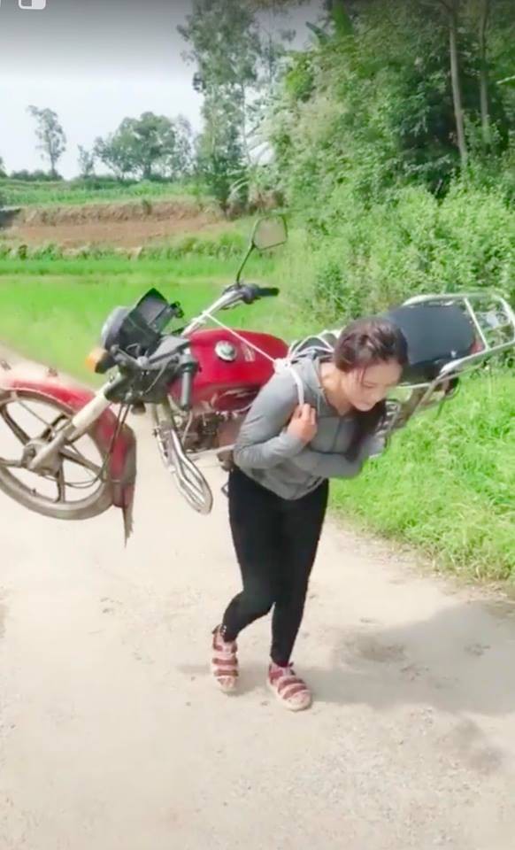 Cô gái cõng cả chiếc xe máy trên lưng nhẹ nhàng như một chiếc balo khiến cánh đàn ông thán phục - Ảnh 2. Cô gái cõng cả chiếc xe máy trên lưng nhẹ nhàng như một chiếc balo khiến cánh đàn ông thán phục - Ảnh 2.