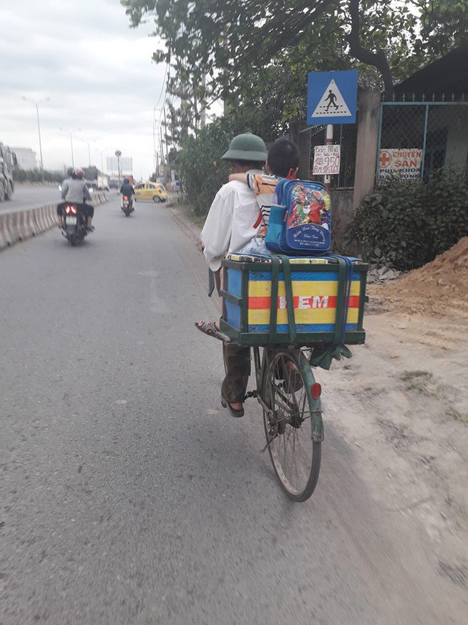 Bố đèo con nhỏ trên xe đạp, chữ viết phía sau thùng hàng khiến nhiều người nghẹn ngào - Ảnh 1.