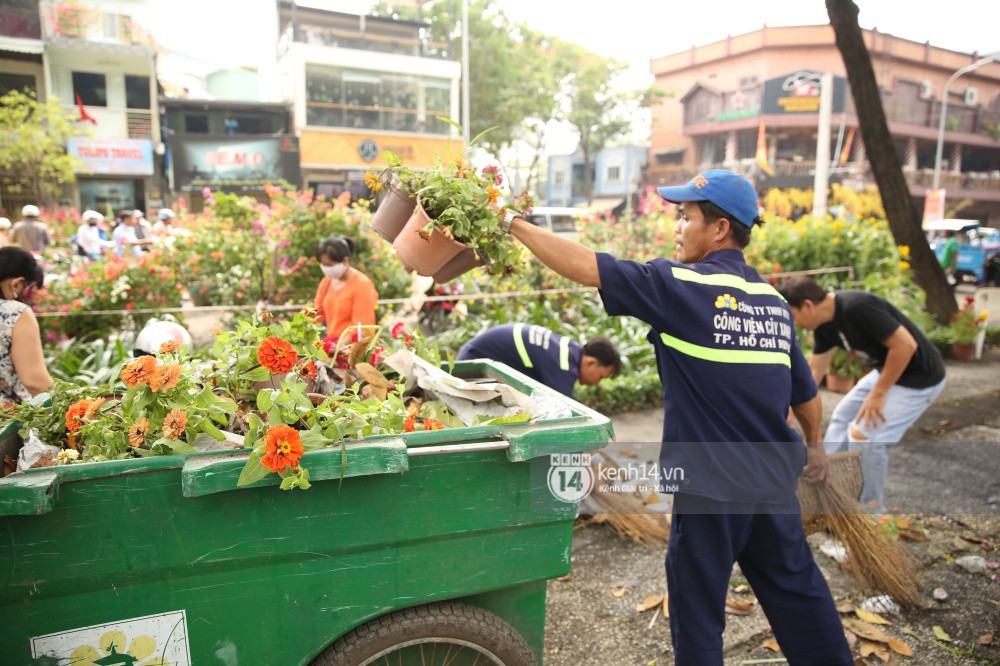 Clip: Không bán hết hàng trưa 30 Tết, nhiều tiểu thương tự tay đập nát chậu hoa, vứt vào thùng rác - Ảnh 11. Một số công nhân môi trường bắt đầu dọn dẹp số hoa bị đập nát lên xe rác