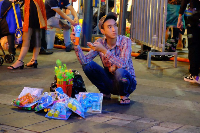 Đẩy xe lăn, người đàn ông này vẫn chen vào dòng người trên phố, bán từng tấm vé số mưu sinh đêm Giao thừa - Ảnh 12.