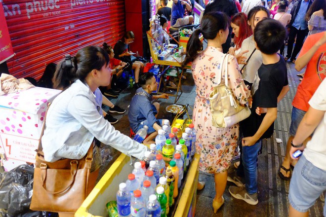 Đẩy xe lăn, người đàn ông này vẫn chen vào dòng người trên phố, bán từng tấm vé số mưu sinh đêm Giao thừa - Ảnh 4.