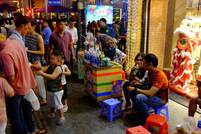 Đẩy xe lăn, người đàn ông này vẫn chen vào dòng người trên phố, bán từng tấm vé số mưu sinh đêm Giao thừa - Ảnh 5.