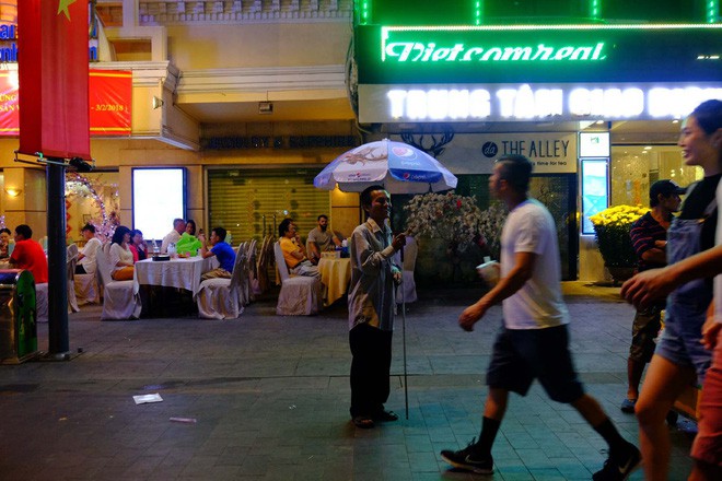  Đẩy xe lăn, người đàn ông này vẫn chen vào dòng người trên phố, bán từng tấm vé số mưu sinh đêm Giao thừa  - Ảnh 10.