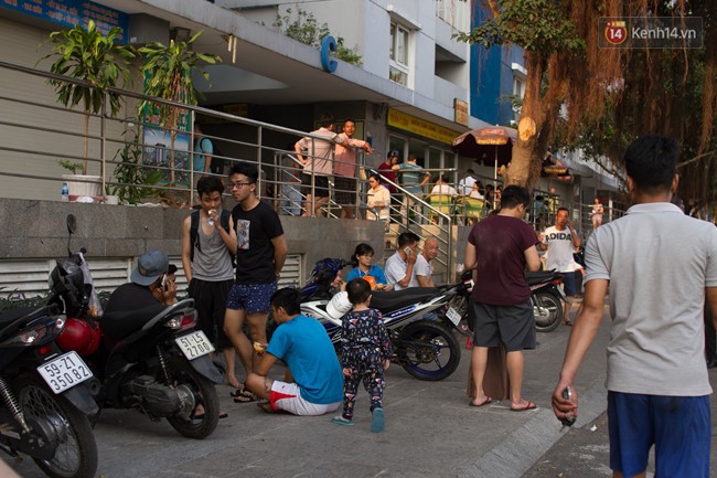 Người dân mệt nhoài nằm khắp vỉa hè, ăn cơm hộp chờ được vào nhà sau những giờ phút hoảng loạn trong vụ cháy chung cư ở Sài Gòn - Ảnh 11.