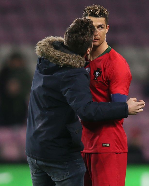 Fan cuồng chạy vào sân cưỡng hôn khiến Ronaldo đơ người - Ảnh 1.