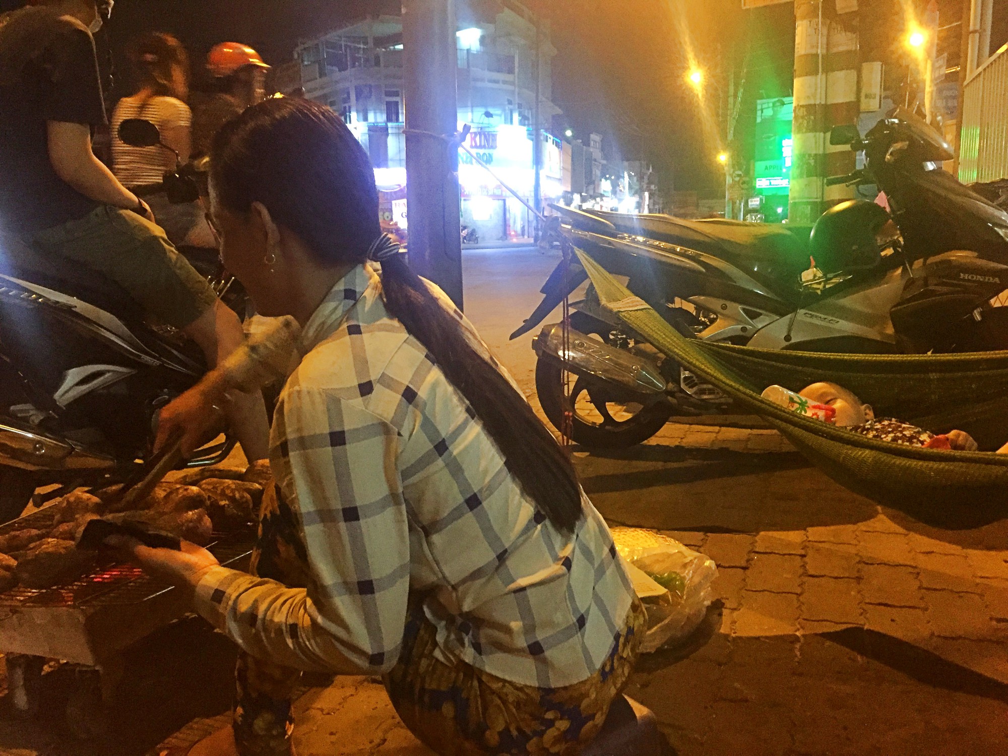Phía sau hình ảnh 2 chiếc võng đong đưa bên lò khoai nướng của người mẹ nghèo ở Sài Gòn - Ảnh 1.