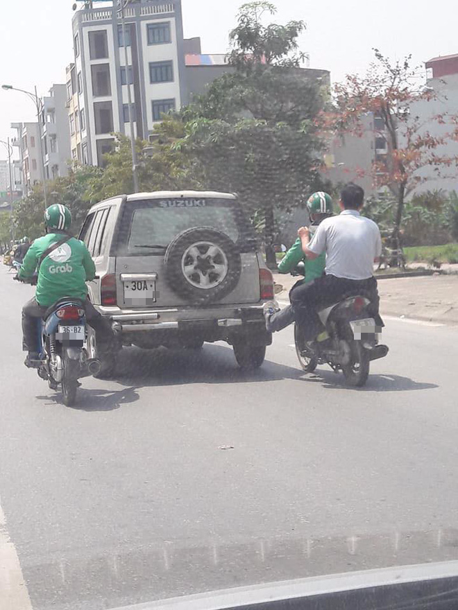 Tình huống hy hữu: 2 tài xế mặc đồng phục GrabBike chung chân đẩy một ô tô chết máy đi bon bon trên đường - Ảnh 1.