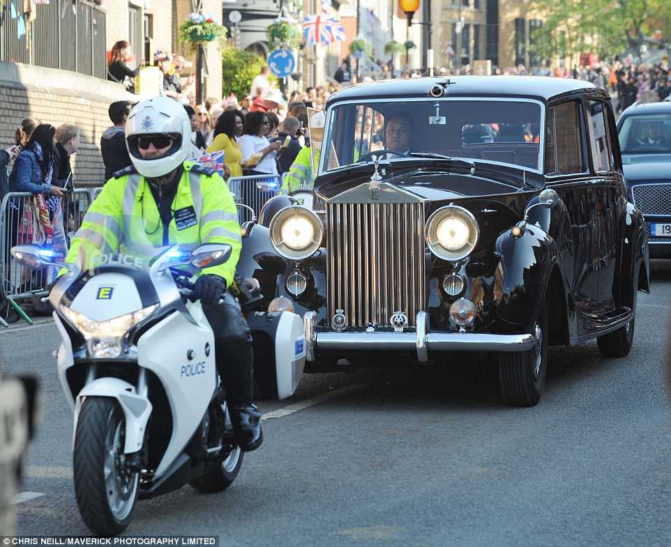 A police escort takes an empty wedding car set to be used in today's big event to the gates of the castle